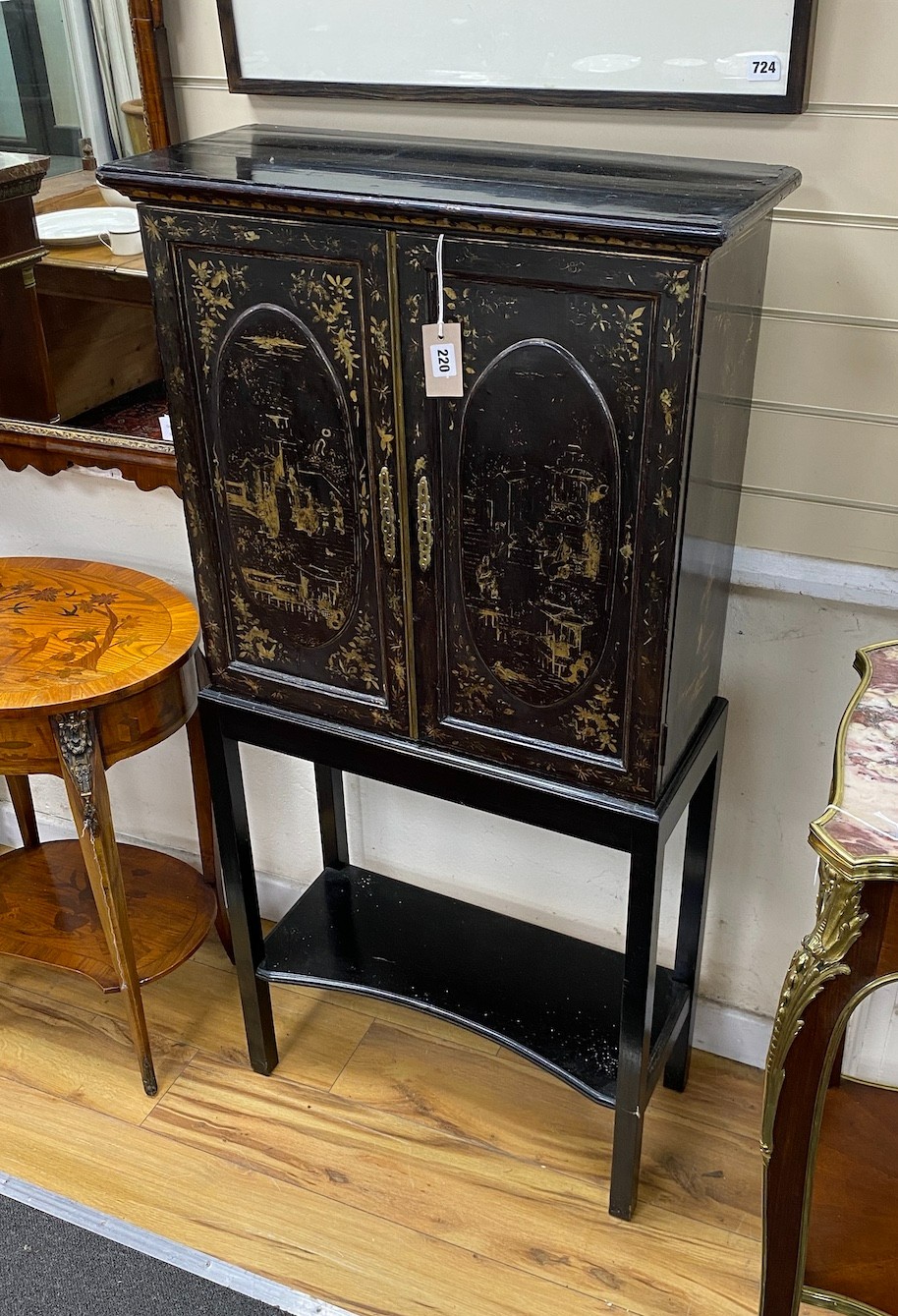 A chinoiserie lacquered two door side cabinet on later stand, width 64cm, depth 27cm, height 130cm